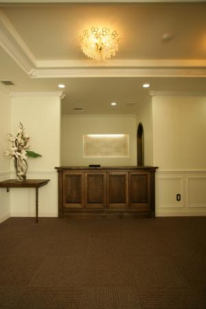 歯科医院受付。後ろの壁にはタイルを貼ってライトアップ。重厚な雰囲気です。