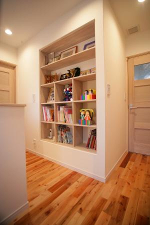 二階への階段を上がると造り付けの本棚が。家族のミニライブラリーです。