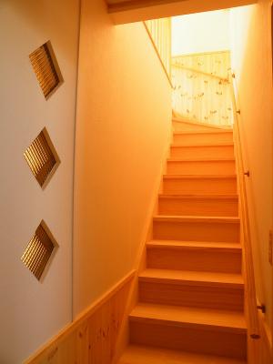２階へ上がる階段横の壁にはガラスブロックをはめてデザイン性と明るさを確保。