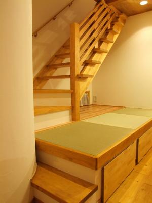2階に上がる階段は畳スペースを利用。ダイニングテーブルのベンチにもなっています。